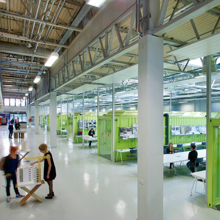 Press kit | 902-02 - Press release | A’ Design Awards 2014 Winners Announced - A' Design Award and Competition - Competition - Architecture Factory&nbsp;<br>Cork Institute of Technology by Marc O Riain &amp; Neil Tobin<br><br>PROJECT DESCRIPTION:<br>The Architecture Factory is a third level education and learning space situated in a disused split-level warehouse. The brief was informed primarily by cost effective occupancy and the desire for studio pedagogy. The design avoided traditional subdivision of walls and ceilings; requiring sub divided servicing and expensive firewalls. 6 shipping containers function as lecturer's offices dividing the space it into open studios separated from a mezzanine by an open boulevard acting as an exploration-learning lab, an opportunistic exhibition space, and the main circulation. Creating a visually open connection between occupants to encourage interaction between peer groups. Below the mezzanine frameless glazing minimally delineate the recessed acoustic boundaries avoiding a long monolithic horizontal interior façade. The balcony anamorphically distorts the perspectival emphasis. First floor transparencies offer excitement and vista to the activities below. Green shipping containers, reuse embodied energy and radiate a chromatic energy within the space. Roof sections are serrated creating a repetitive texture angled southward for light and away from the mezzanine windows for privacy. The resulting textural composition creates differing cognate compositions depending on whether they are viewed from above or below. Open plan studios occupy parti spaces between geometric organizations of containers in un-partitioned relief. Dedicated work-spaces with wire shelving above, function as both storage and acoustic baffle. The 6 acoustically open offices and studios function intelligibility well. Enclosed seminar rooms below the mezzanine provide more acoustically private spaces for theory delivery and discussion. Student-to-student learning is a natural consequence. The industrial heritage of the building strongly influenced how the scheme aesthetic maintained the genius loci. The use of containers reflects the manufacturing process. The white and grey provides an interior canvas carefully refined to minimize complexity. Color proportionality and density emphasizes the containers but is sensitively balanced not to perceptively dominate the space.&nbsp; - Photo credit: Janice O Connell F22 Photography