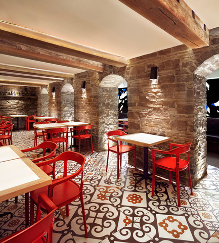 Press kit | 1048-09 - Press release | Spanish-inspired tapas restaurant Barsa Taberna captures the energy of the running of the bulls - +tongtong - Commercial Interior Design - Old stone archways differentiate the grotto-style dining area, a very tight, dark and windowless space with low ceilings and wooden beams. The tiles running throughout the space is purposefully laid to draw attention to the nonlinear nature of the space. The tile pattern itself is a modern take on traditional patterns from the art nouveau and gothic periods.<br> - Photo credit: Lisa Petrole Photography<br>