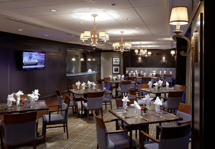 Dossier de presse | 1855-01 - Communiqué de presse | Newcombe Design Group’s approach to retirement living honoured with ARIDO Award - Newcombe Design Associates - Design d’intérieur commercial - <p></p>Residents enjoy a choice of banquette or loose seating near the Terrace Grille open kitchen. Darker wood paneling and traditional decorative fixtures establish a pub-like character, differentiating this dining area from Christopher’s, the fine dining room. - Crédit photo : David Whittaker