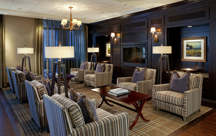 Dossier de presse | 1855-01 - Communiqué de presse | Newcombe Design Group’s approach to retirement living honoured with ARIDO Award - Newcombe Design Associates - Design d’intérieur commercial - In the Terrace Grille lounge, seating flanks the elevated fireplace, which can be seen from the adjacent dining area. Hardwood flooring defines circulation, the lounge and dining area.&nbsp; - Crédit photo : David Whittaker
