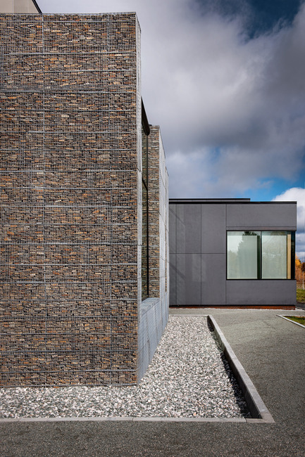 Dossier de presse | 755-05 - Communiqué de presse | Centre technologique des résidus industriels (CTRI) - Groupe Conseil Trame / BGLA - Architecture institutionnelle -  Vue des murs en gabion contrastant avec les panneaux de fibre de béton  - Crédit photo : Christian Perreault