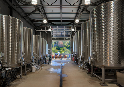 Press kit | 2039-01 - Press release | Titus Vineyards - MH Architects - Industrial Architecture - Lined with 6000-gallon fermentation tanks on either side and a metal truss roof above, the Fermentation Room overlooks the Covered Crush area beyond.&nbsp; Fermentation is a six-week, highly-controlled process that involves the conversion of glucose to carbon dioxide, heat, and ethyl alcohol.&nbsp;    - Photo credit:  Technical Imagery Studios  