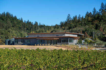Press kit | 2039-01 - Press release | Titus Vineyards - MH Architects - Industrial Architecture -    The west façade of Titus Winery is characterized by the covered Hospitality area overlooking surrounding vineyards. &nbsp;Exterior materials include cedar soffits, concrete board-form tilt-up walls, gunmetal blue panels above windows, and anodized aluminum window frames.&nbsp;    - Photo credit: Technical Imagery Studios
