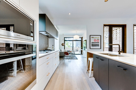 Press kit | 2344-01 - Press release | 46H - Sustainable Reinvention of 1905 House in the Beaches - baukultur/ca - Residential Architecture -    Kitchen looking towards Family Room in Rear of House: Kitchen cabinets with white &amp; black extra matt surfaces in combination with walnut detailing and copper pulls<br><br>    - Photo credit: SilverHouse
