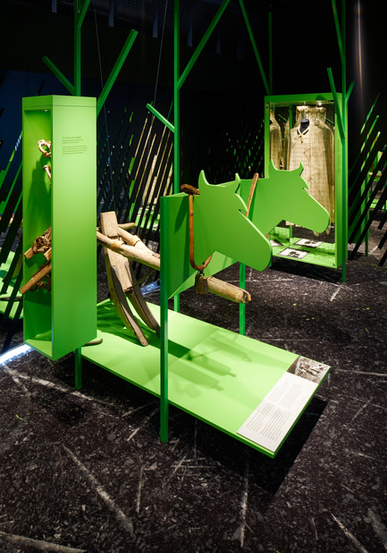 Dossier de presse | 2341-01 - Communiqué de presse | Torsby Finnskogscentrum - Bornstein Lyckefors arkitekter - Architecture commerciale - Stylized trees from green steel hold the exhibition, the green colour of the tree trunks are taken from small birch shot that just shoots up out of the earth. &nbsp;The floor is a printed carpet depicting the burned ground. - Crédit photo : Åke E:son Lindman