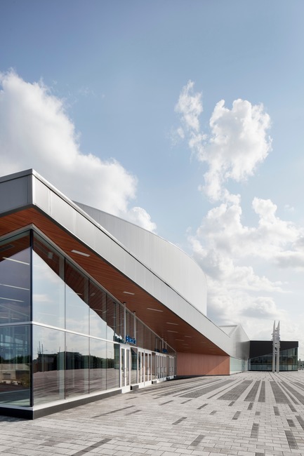 Dossier de presse | 865-28 - Communiqué de presse | Incontournable, la Place Bell redéfinit le concept d'aréna - Lemay - Architecture commerciale -  Entrée de l'amphithéâtre&nbsp;avec l'œuvre d’art public "Faire la vague" du sculpteur Michel Goulet  - Crédit photo : Adrien Williams