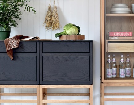 Dossier de presse | 1122-04 - Communiqué de presse | Cuisines Steam à la conquête du modulaire - Cuisines Steam - Produit -  Collection volitare - de gauche à droite - C°2 combinaison de modules bas présentés en chêne teint nuit profonde et pattes en chêne blanc. Comptoir Fenix noir. C°2 armoire vaisselier fait de chêne blanc avec cadrage de portes en métal peint bronze.  - Crédit photo : Co°quo