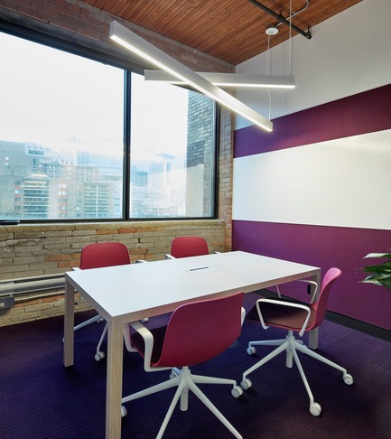 Dossier de presse | 1513-01 - Communiqué de presse | Slack Toronto Office - Dubbeldam Architecture + Design - Design d’intérieur commercial -  Meeting rooms are each coordinated around a different, bold colour. This room features a dark magenta carried through the Stylex chairs,Interface carpet, and Designtex acoustic wallcovering, which is offset by the whiteboard, Actiu meeting table edged in birch, and angled white light fixtures by Lumenwerx.<br>  - Crédit photo : Shai Gil