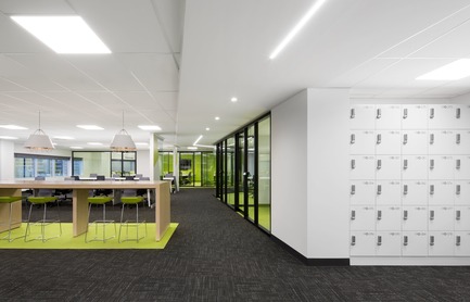 Dossier de presse | 1195-01 - Communiqué de presse | Un nouvel environnement dynamique de travail pour la Banque Nationale - VAD Designers d'espaces - Design d’intérieur commercial -  Des casiers d'appoint pour le personnel s'intègrent discrètement au concept dans un alcôve blanc. <br>Au plafond, une retombée a été pensée pour contenir l'éclairage intégré au LED qui souligne le corridor de circulation entourant le noyau.&nbsp;<br>  - Crédit photo : Stéphane Brügger