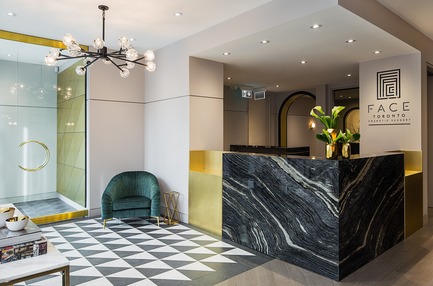 Dossier de presse | 2185-05 - Communiqué de presse | FACE Cosmetic Surgery - Audax - Design d’intérieur commercial -  Entrance featuring black and white stone patterned floor, veined marble reception desk and brass accents - Crédit photo : Erik Rotter
