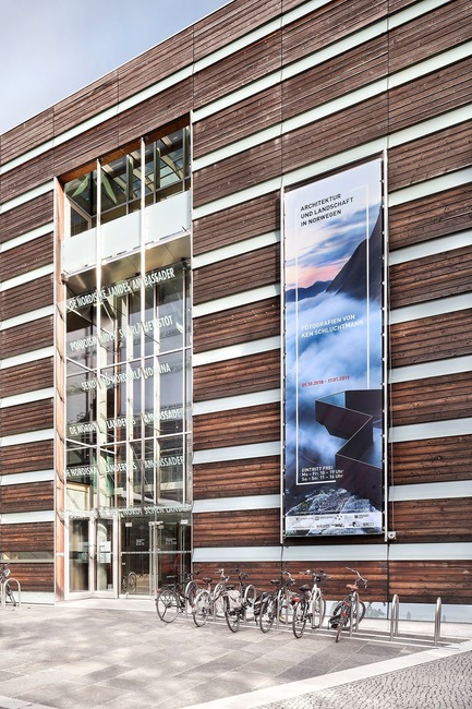 Dossier de presse | 3469-01 - Communiqué de presse | Exhibition “Architecture and Landscape in Norway” - Photographs by Ken Schluchtmann - Ken Schluchtmann - diephotodesigner.de - Évènement + Exposition - Entrance of the Felleshus, Nordic Embassies Berlin with large exhibition banner. - Crédit photo :         © Ken Schluchtmann -&nbsp; diephotodesigner.de