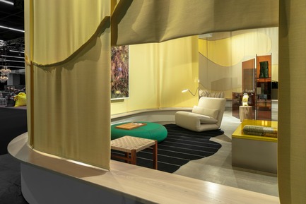 Dossier de presse | 2704-05 - Communiqué de presse | “Das Haus” 2019 at the imm cologne: Living by moods creates an appetite for open-plan homes - imm cologne 2019, Koelnmesse GmbH - Design d’intérieur résidentiel - A view through a curtain “window” into the Reclining zone of “Living by Moods”, the Das Haus installation by Studio Truly Truly at imm cologne 2019. The low furniture, dark colours and soft shapes (Tattomi armchair, De Padova; Aswan stool, e15; Strata rug and Hatch pouf, prototypes by Studio Truly Truly) invite you to lay back and relax. - Crédit photo : Constantin Meyer; Koelnmesse