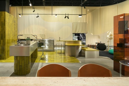 Dossier de presse | 2704-05 - Communiqué de presse | “Das Haus” 2019 at the imm cologne: Living by moods creates an appetite for open-plan homes - imm cologne 2019, Koelnmesse GmbH - Design d’intérieur résidentiel - The Active zone of the Das Haus 2019 installation that Studio Truly Truly designed for imm cologne is dominated by clear lines and stimulating colours, with gleaming surfaces that reflect the bright lighting. The lime green tiles (Made a Mano), stainless steel kitchen blocks and Kvadrat curtain surrounding Das Haus add up to a highly distinctive character. - Crédit photo : Constantin Meyer; Koelnmesse
