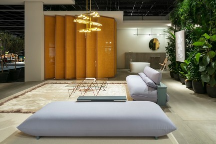 Dossier de presse | 2704-05 - Communiqué de presse | “Das Haus” 2019 at the imm cologne: Living by moods creates an appetite for open-plan homes - imm cologne 2019, Koelnmesse GmbH - Design d’intérieur résidentiel - The new Press sofa (also seen here as a long pouf in the foreground) is a prototype (produced by Käfer &amp; Hummel). It was developed by Studio Truly Truly for their Das Haus at imm cologne 2019 and was shown at the Cologne fair for the first time. The Serene zone with the bathroom and a sleeping area hidden behind panels is visible in the background. - Crédit photo : Constantin Meyer; Koelnmesse