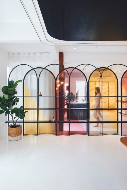 Dossier de presse | 3903-01 - Communiqué de presse | Mantab Workplace - S/LAB10 - Design d’intérieur commercial - White epoxy floor and white space in contrast with arched translucent coloured display screen. Person exiting the entry door on first floor&nbsp;of reception area. - Crédit photo : Heartpatrick