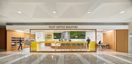 Press kit | 2682-01 - Press release | Innovation Through Design - The Symbiotic Link Between Branding and Architecture - Williamson Williamson Inc. - Commercial Interior Design -      Pilot First Canadian Place Cafe: An oversized picture window frames three bright yellow standing bars.<br>[Completion Date: September 2017]    - Photo credit:  Scott Norsworthy 