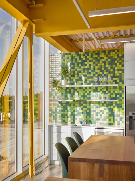 Press kit | 2682-01 - Press release | Innovation Through Design - The Symbiotic Link Between Branding and Architecture - Williamson Williamson Inc. - Commercial Interior Design -    Pilot Wagstaff Office Addition: A Pilot Yellow steel tension member supports the lower beam while green pixelated tile and a custom white oak lunch table provide texture in the space.&nbsp;<br>[Completion Date: 2018]<br>     - Photo credit: Scott Norsworthy