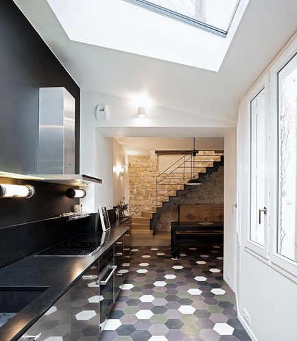 Dossier de presse | 3894-01 - Communiqué de presse | Une maison de ville unifamiliale à Paris - Alia Bengana + Capucine de Cointet architectes - Architecture résidentielle - Kitchen open to the entrance and dining room, cement tile floor, steel and stainless steel door kitchen and black granite worktop<br> - Crédit photo : David Cousin-Marsy