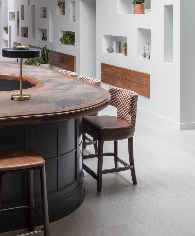 Press kit | 2886-03 - Press release | objekts - SkB Architects - Commercial Interior Design - Detail of the marble and walnut-topped, horseshoe-shaped bar with the sculptural library wall behind. - Photo credit: Nicholas Worley