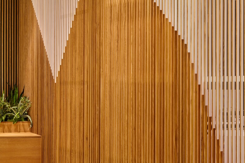 Press kit | 2682-01 - Press release | Innovation Through Design - The Symbiotic Link Between Branding and Architecture - Williamson Williamson Inc. - Commercial Interior Design - Pilot Manulife: The pattern on the closed gates was derived from the steps used to fold a paper airplane. It is painted on one side of each slat - with a different colour on the opposite side - so the patterns change as you move around the cafe walls.   - Photo credit: Scott Norsworthy