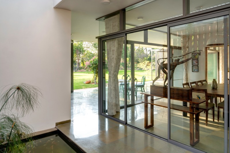 Press kit | 4016-02 - Press release | An Atypical Single User Villa - SquareWorks - Residential Architecture - Interstitial circulation between lily-pond and dining  merging indoors and outdoors - Photo credit: Fabien Charuau