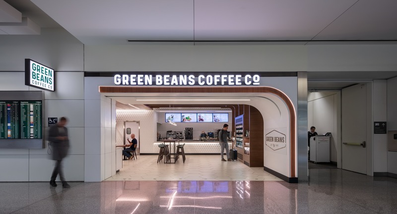 Dossier de presse | 2757-17 - Communiqué de presse | WDA announces new projects at San Francisco international airport - WDA | William Duff Architects - Architecture commerciale -  <p>Critical to the design for Green Beans’ new outpost in the International Terminal at SFO was the company’s desire to create “cafes of calm” for busy people.  WDA realized a comfortable environment evoked through natural materials, warm lighting and textured finishes.  At the entrance, the outline of walnut, which sweepingly curves down from the ceiling  to the coffee brand’s logo, initiates a welcoming gesture, while framing a view into the space.</p>    - Crédit photo :   Eric Rorer Photography  