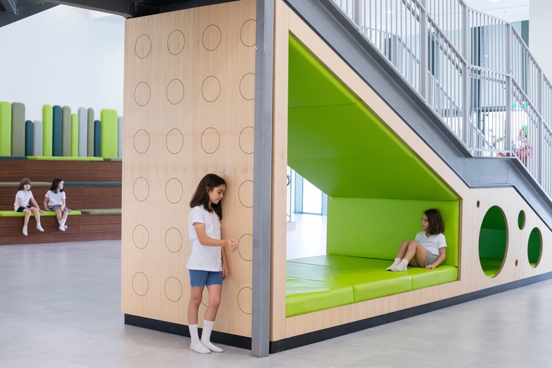Dossier de presse | 3671-01 - Communiqué de presse | The First Inclusive School in Tel Aviv by Sarit Shani Hay - Sarit Shani Hay Design Studio - Design d’intérieur commercial - Space in the main entrance underneath the stairs designed for playful activities - Crédit photo : Roni Cnaani