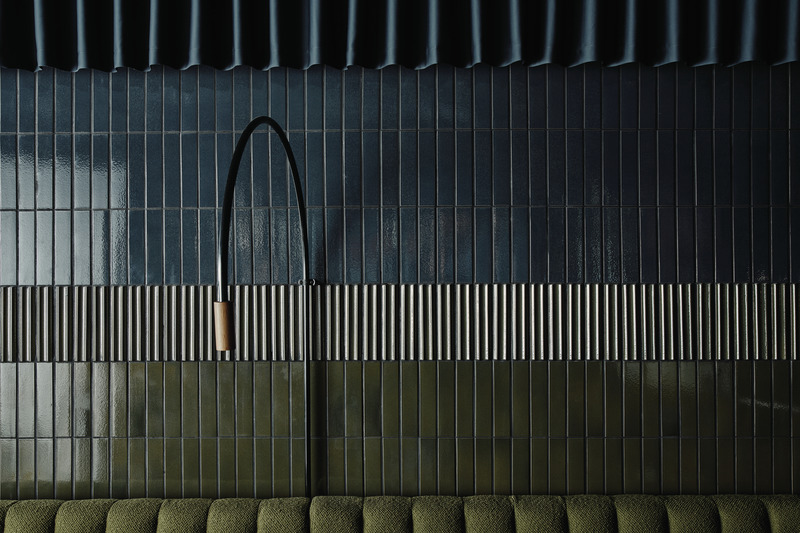 Press kit | 2506-06 - Press release | Modern Interpretation of a Speakeasy Bar - AGROB BUCHTAL - Commercial Interior Design -  Perfect colour harmony between curtain-like wall decoration (top), bench (bottom) and the ceramic tiles produced by long-time firing in a classic tunnel kiln (Craft series of Agrob Buchtal). The three-dimensional variant from the same collection, which is used in the centre, divides the wall and creates attractive visual effects with its wave profile.  - Photo credit:  agrob-buchtal.de / Riikka Kantinkoski 
