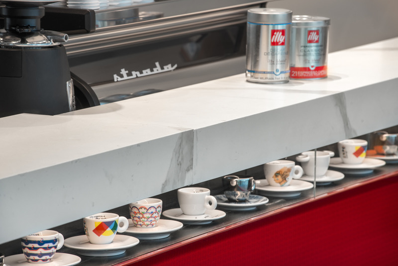 Dossier de presse | 2757-20 - Communiqué de presse | William Duff Architects' Latest Projects at SFO Showcase Trends in Airport Dining Amenities - William Duff Architects (WDA) - Architecture commerciale - <p class="">Illy Caffé: The signature red bar at Illy's SFO Terminal 1 location, features a metal-facing pattern as well as espresso cups nestled in hand-crafted casework below the counter.</p> - Crédit photo : <p class="">Patrik Argast</p>