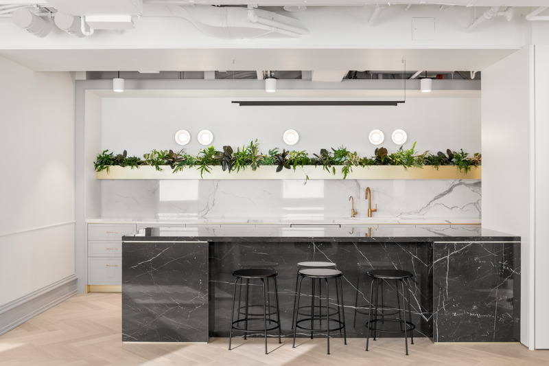 Dossier de presse | 5571-01 - Communiqué de presse | Return to Work Post Pandemic: How Financial Firm Transforms the Workplace - Edit Studios Inc. - Design d’intérieur commercial - The modern bar is outfitted with all the comforts of home highlighted by book matched black and white marble with gold accents.  - Crédit photo : Ema Peter Photography