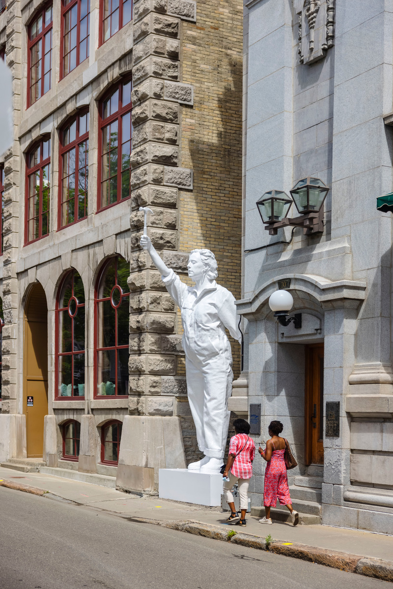 Dossier de presse | 2402-04 - Communiqué de presse | PASSAGES INSOLITES 8e édition : l'art prend ville! - EXMURO arts publics - Évènement + Exposition -  <p class="">Valérie Potvin (Québec, Québec), "La sculptrice", 2021 </p><p class=""><br></p><p class="">Une figure statuesque surgit d’une ruelle dotée d’un marteau, un outil typiquement employé en sculpture, telle une héroïne brandissant ses armes. Dans un jeu de mise en abîme fort évocateur, c’est celle qui a réalisé l’oeuvre qui s’y est autoreprésentée. Valérie Potvin pose ainsi un geste d’affirmation de son propre statut d’artiste. Stoïque et inébranlable sur son socle, le monument de blanc immaculé rend aussi hommage à la force des femmes et à leur place incontestable dans la pratique de l’art public. </p><p class=""><br></p><p class="">La création de cette oeuvre a été rendue possible grâce à l’appui financier du Conseil des arts du Canada. </p>  - Crédit photo : Stéphane Bourgeois_EXMURO