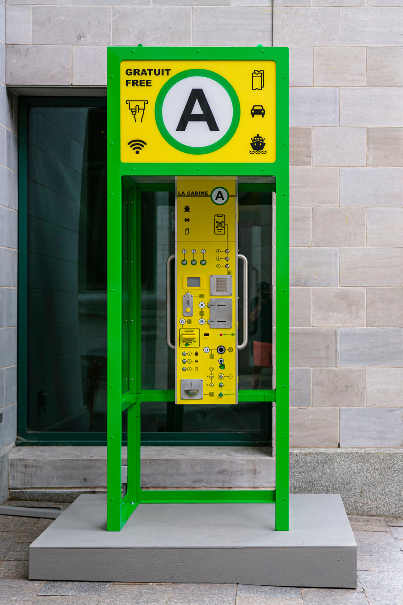 Dossier de presse | 2402-04 - Communiqué de presse | PASSAGES INSOLITES 8e édition : l'art prend ville! - EXMURO arts publics - Évènement + Exposition - <p class="">Yann Farley (Sainte-Justine, Québec), "La Cabine A", 2021 </p><p class=""><br></p><p class="">"La Cabine A" est une borne de paiement qui se fond dans le paysage urbain avec son interface familière, habillée de pictogrammes universellement lisibles, et la promesse intrigante d’une gratuité quelconque. Toute tentative d’activer la machine est pourtant entravée par sa surabondance d’instructions absurdes, jusqu’à ce qu’on se rende compte de sa futilité et du canular que nous a tendu l’artiste. Cette sculpture électroacoustique interactive dresse une caricature de la relation ambiguë que nous entretenons avec les dispositifs automatisés aujourd'hui omniprésents. </p> - Crédit photo : Stéphane Bourgeois_EXMURO