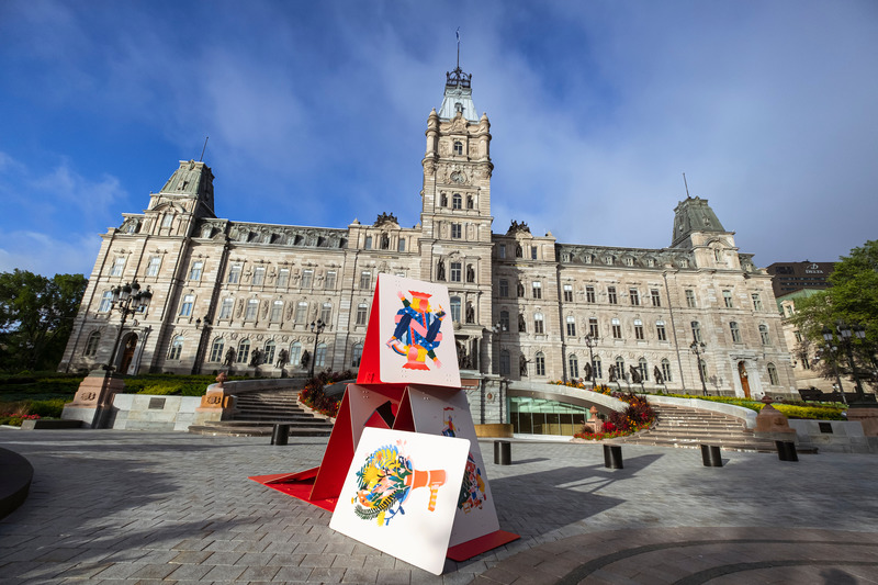 Dossier de presse | 2402-04 - Communiqué de presse | PASSAGES INSOLITES 8e édition : l'art prend ville! - EXMURO arts publics - Évènement + Exposition -  <p class="">Charles-Étienne Brochu (Québec, Québec), "Sommet de la montagne", 2020</p><p class=""> </p><p class="">Un château de cartes monumental aux illustrations colorées s’érige devant le parlement. L’oeuvre renvoie à la précarité de l’équilibre sociétal tout en représentant la dualité caractéristique de nos institutions, à la fois précieuses et fragiles tout en étant vigoureuses et résilientes. À l’instar de la société québécoise, l'édification d’un château de cartes requiert beaucoup de soin et de vigilance. Un seul coup de vent ou mouvement brusque et tout ce qu'on a construit pourrait s’effondrer...</p><p class=""> </p><p class="">Présentée en partenariat avec l’Assemblée nationale du Québec.</p><p class="" style=""><br style=""></p>  - Crédit photo : Stéphane Bourgeois_EXMURO