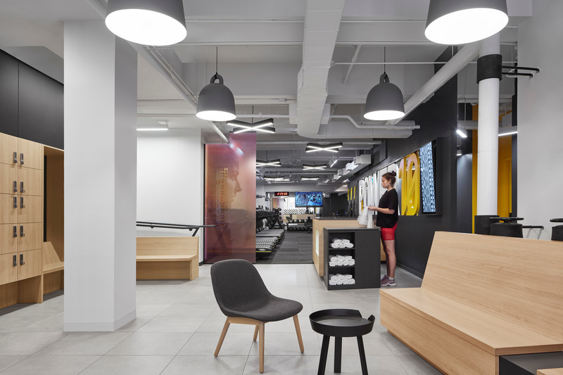 Dossier de presse | 1513-04 - Communiqué de presse | Power10 Fitness - Dubbeldam Architecture + Design - Design d’intérieur commercial -  Built-in benches in the lounge area allow members to refuel and relax, while the open area can also be used for small events and educational sessions Large Normann Copenhagen Bell Pendants suspended above allude to the equipment used in strength training.<br>  - Crédit photo : Riley Snelling