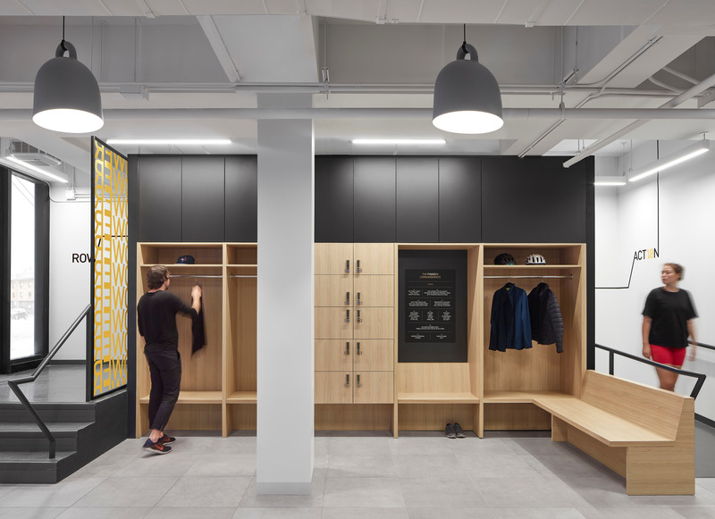 Dossier de presse | 1513-04 - Communiqué de presse | Power10 Fitness - Dubbeldam Architecture + Design - Design d’intérieur commercial -  Integrated custom lockers, coat rails and shelves are located at the entrance. White oak millwork is combined with the smooth tiles on the floor, conveying an elevated fitness club experience.  - Crédit photo : Riley Snelling<br>