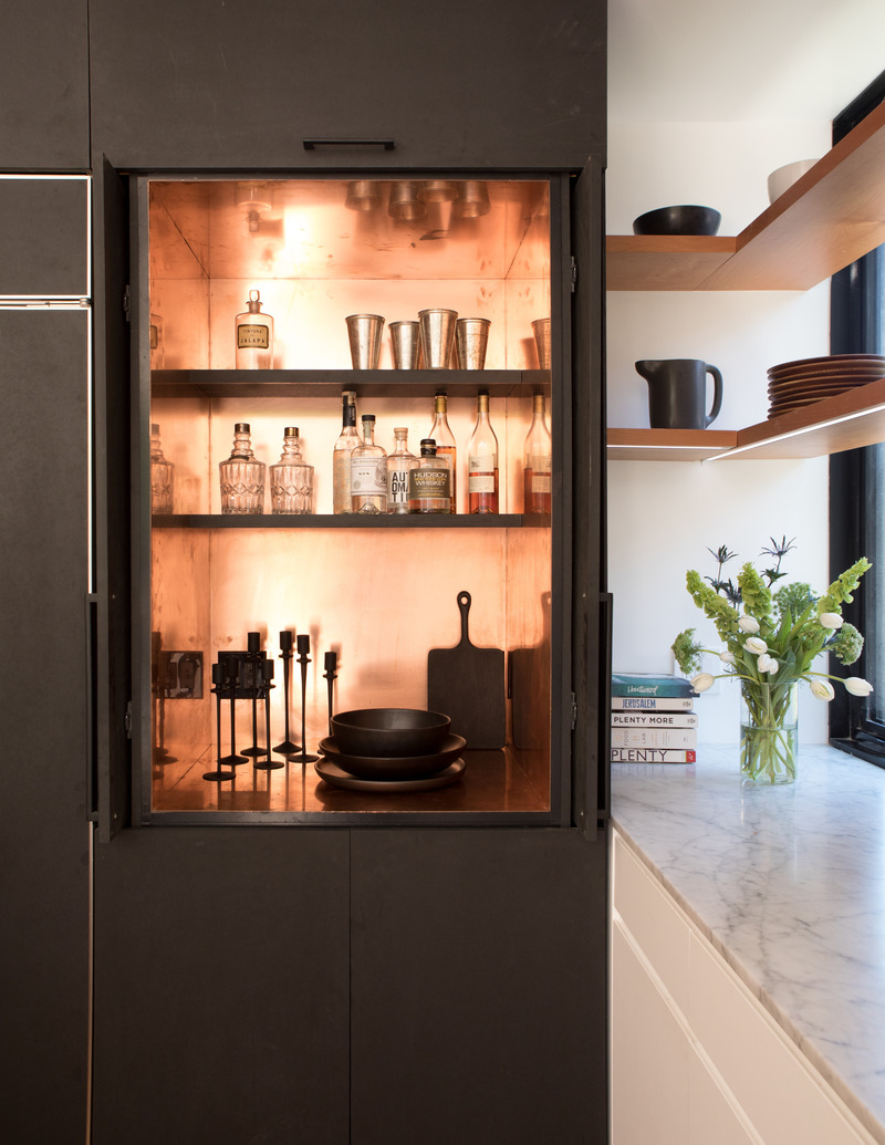 Press kit | 2757-25 - Press release | Medium Plenty's Holistic Designs Are Defined by Material Honesty - Medium Plenty - Residential Architecture -   Walavista Residence:  The mostly black and white palette of the addition is highlighted throughout the kitchen where black matte cabinets, marble counters and backsplash are complemented by warm woods, a rich caramel colored leather banquette and a copper lined appliance nook/cocktail bar.  - Photo credit: Melissa Kaseman Photography