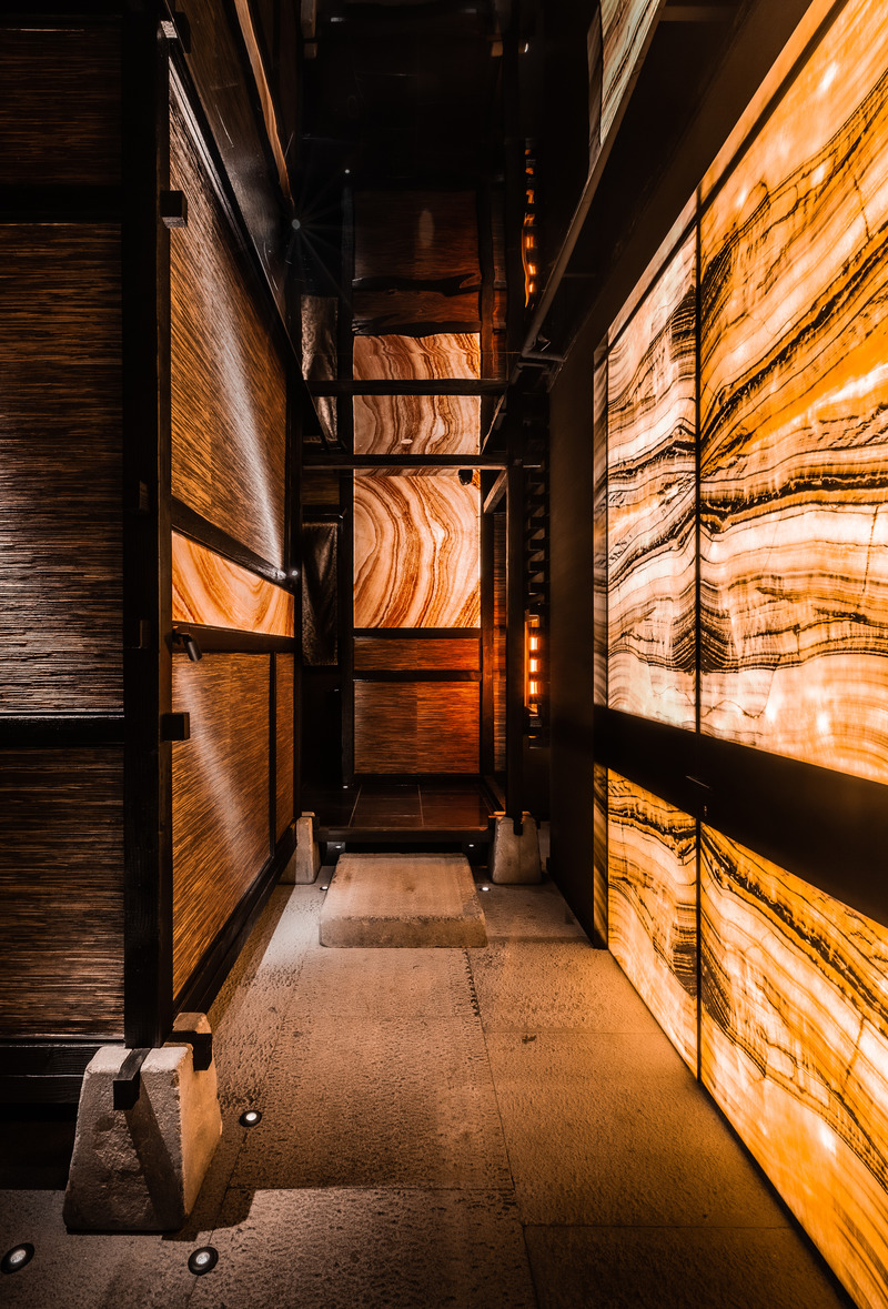 Press kit | 5577-02 - Press release | T0 Sumibi Yakiniku | Shibuyanaka Sushi - Nong Studio - Commercial Interior Design - <p class="">The luminous onyx on entrance door and wall creates a magical dialogue, in which give you a sense of being in a volcano .</p> - Photo credit: Hei Nong