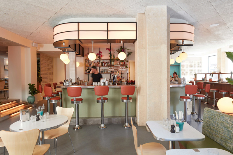 Press kit | 5857-01 - Press release | Cali Uptown - Studio UNLTD - Commercial Interior Design -  The horseshoe-shaped bar forms the energetic core of the space and is defined by an internally lit soffit that emits a warm glow.  - Photo credit: Le Boulicaut Photographe