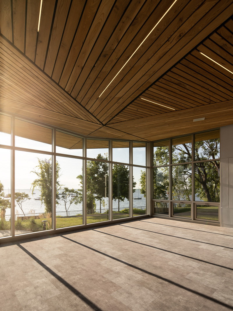 Dossier de presse | 1676-05 - Communiqué de presse | Le Centre nautique de la Baie-de-Valois à Pointe-Claire : un pôle d'activités pour se réapproprier les berges de l'île de Montréal - ADHOC Architectes & Prisme Architecture - Architecture institutionnelle -   Le geste du toit se traduit à l’intérieur du bâtiment, créant une atmosphère immersive qui révèle poétiquement des vues imprenables sur le fleuve.    - Crédit photo : Raphaël Thibodeau
