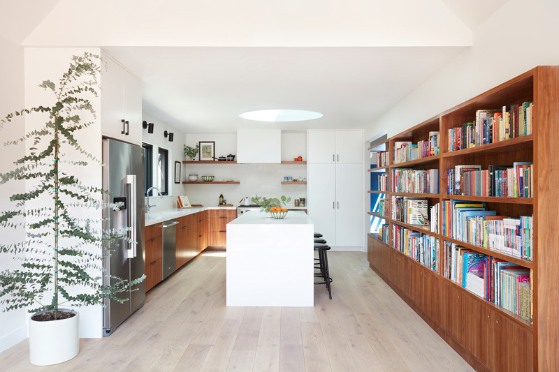 Press kit | 2757-32 - Press release | Medium Plenty Transforms a Southern California Residence into a Multi-Generational Abode - Medium Plenty - Residential Architecture - In the new kitchen, a custom bookshelf and cabinets made of walnut wood wrap around into the living room to house the client's extensive book and record collection.  - Photo credit: Mariko Reed