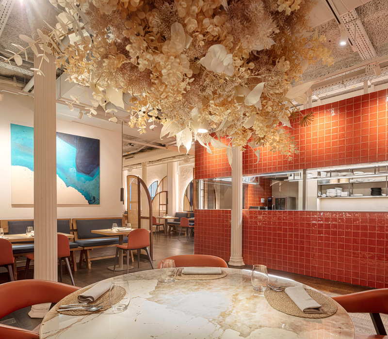 Dossier de presse | 3724-11 - Communiqué de presse | Compartir Restaurant - EL EQUIPO CREATIVO - Design d’intérieur commercial - The open kitchen, with a simple shape and a bold colour,  is one of the protagonists of the dining room, together with the blue pictorial "window".  - Crédit photo : Adria Goula
