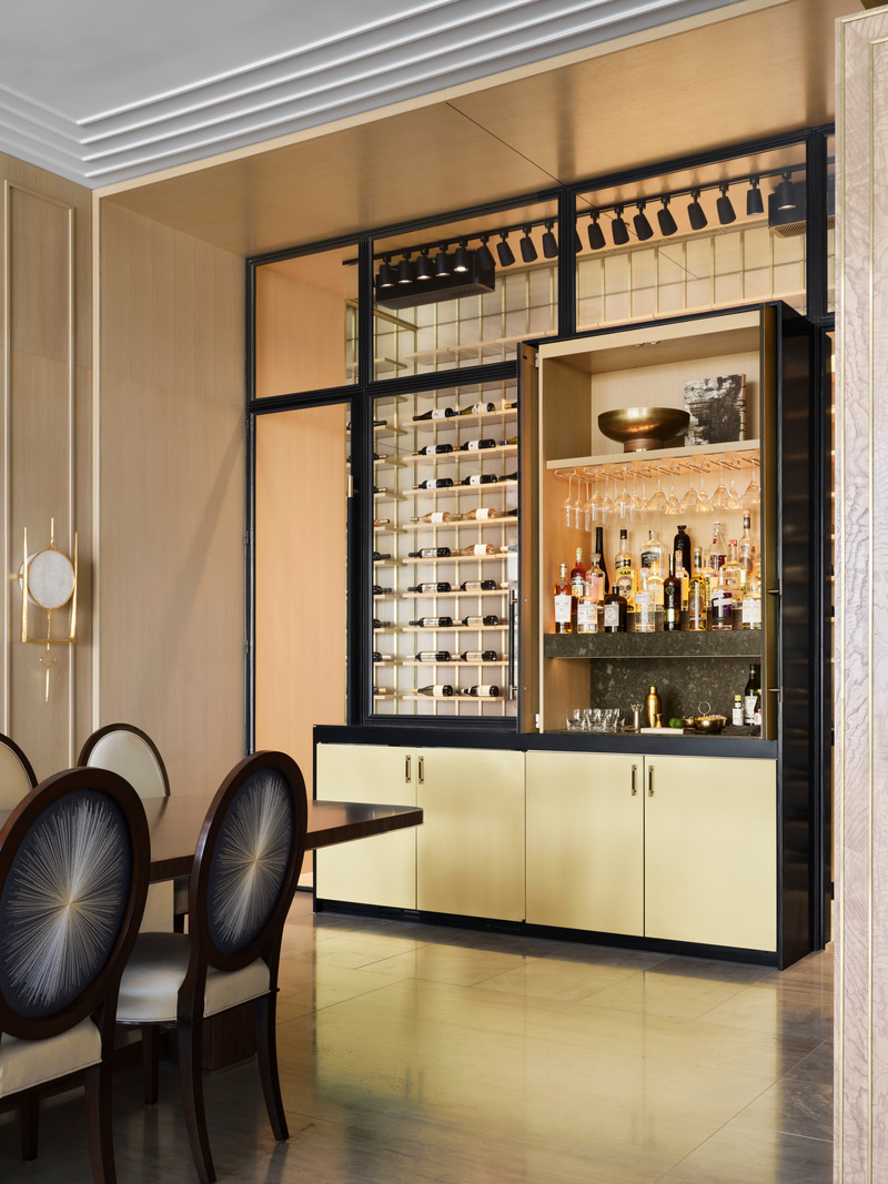 Press kit | 6087-03 - Press release | Family Connections: a Five-Star Retreat in the Desert Southwest - Daniel Joseph Chenin, Ltd. - Residential Interior Design - A hidden bar wrapped in brass, sits at the end of the main dining room with a view into the walk-in wine cellar beyond - Shown Open. - Photo credit: Douglas Friedman