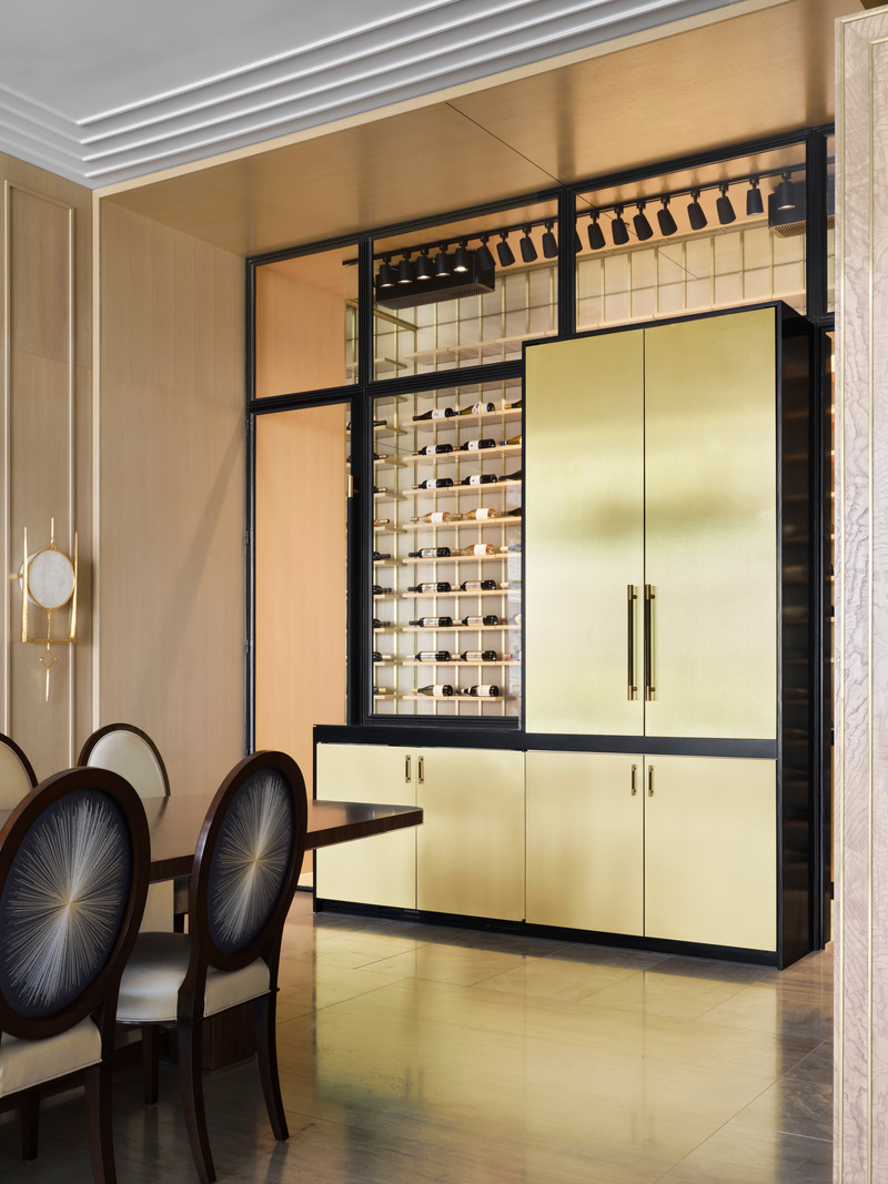 Press kit | 6087-03 - Press release | Family Connections: a Five-Star Retreat in the Desert Southwest - Daniel Joseph Chenin, Ltd. - Residential Interior Design - A hidden bar wrapped in brass, sits at the end of the main dining room with a view into the walk-in wine cellar beyond - Shown Closed. - Photo credit: Douglas Friedman