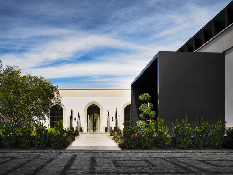 Press kit | 6087-03 - Press release | Family Connections: a Five-Star Retreat in the Desert Southwest - Daniel Joseph Chenin, Ltd. - Residential Interior Design - An inner courtyard flanked by fountains and sculpted landscape leads to a large black portal that shrouds the main entrance to the home. - Photo credit: Douglas Friedman
