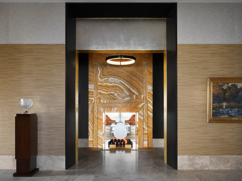 Press kit | 6087-03 - Press release | Family Connections: a Five-Star Retreat in the Desert Southwest - Daniel Joseph Chenin, Ltd. - Residential Interior Design - The powder room vestibule is framed by a portal off the secondary crossing featuring a 12-foot-tall double-sided fireplace clad in orange onyx. - Photo credit: Douglas Friedman