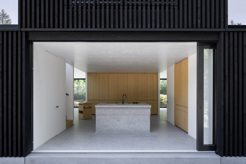 Dossier de presse | 6863-01 - Communiqué de presse | Wooden House by the Lake - Appels Architekten - Architecture résidentielle - <p>The kitchen opens entirely to the outside with sliding doors disappearing inside the walls.</p> - Crédit photo : © Florian Holzherr