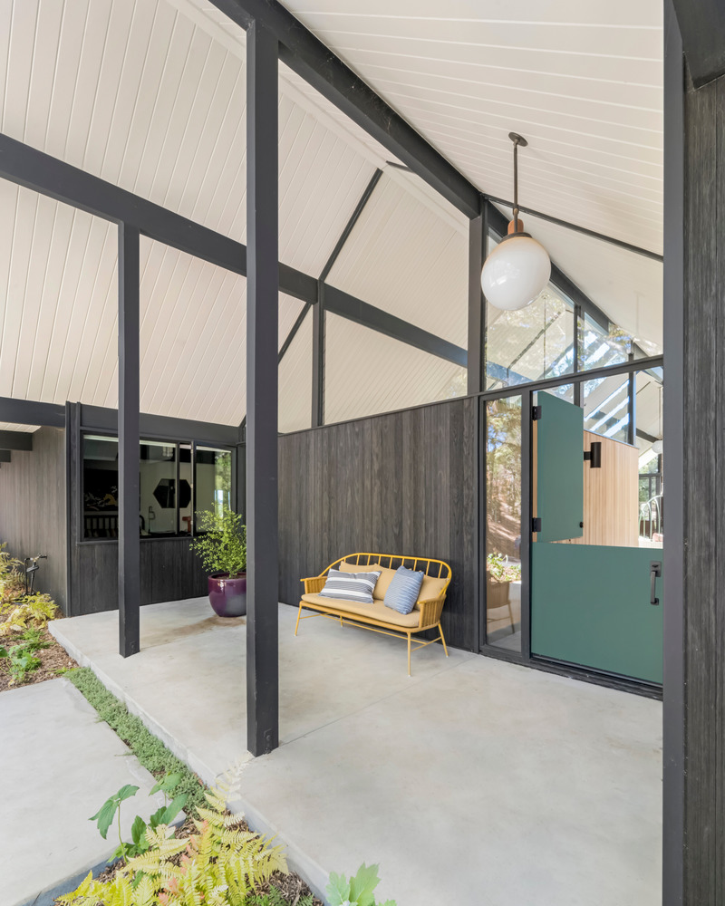 Press kit | 2757-33 - Press release | Gustave Carlson Design Skillfully Stewards an Unlikely Eichler - Gustave Carlson Design - Residential Architecture -  In the entry porch, located underneath the gabled roof, transom windows let in natural light, while showcasing the signature 'Eichler' post-and-beam construction.  - Photo credit: David Duncan Livingston
