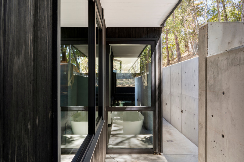 Press kit | 2757-33 - Press release | Gustave Carlson Design Skillfully Stewards an Unlikely Eichler - Gustave Carlson Design - Residential Architecture - Providing both privacy for the primary bathroom and visual interest, a cast-in-place concrete retaining wall features the cone-shaped marks left from the form anchors. - Photo credit: David Duncan Livingston