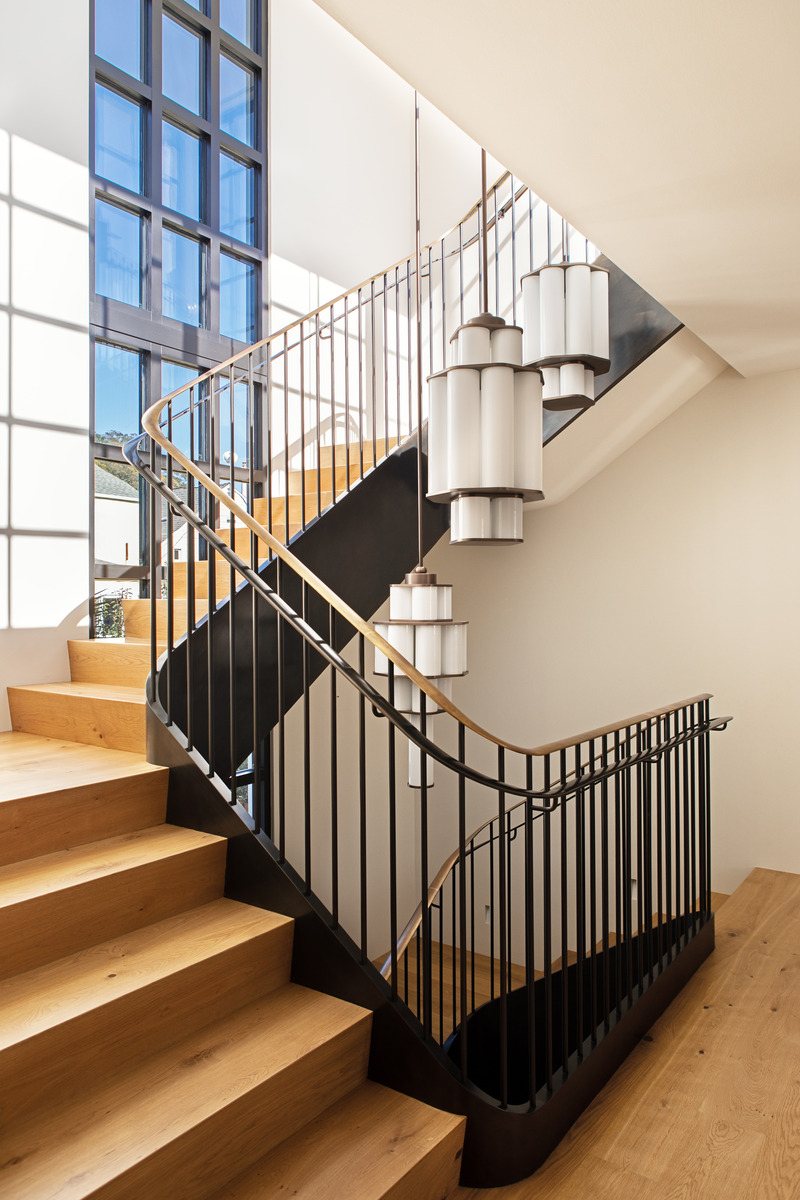 Press kit | 2757-35 - Press release | Medium Plenty Gives a Sprawling Update to a Once Modest 1920s Spanish Revival Home - Medium Plenty - Residential Interior Design -  The custom fabricated steel staircase acts as both the centerpiece and spine of the residence. A three-story, continuous ribbon window accentuates the staircase verticality and provides continuous natural light.   - Photo credit:  Laure Joliet Photography 