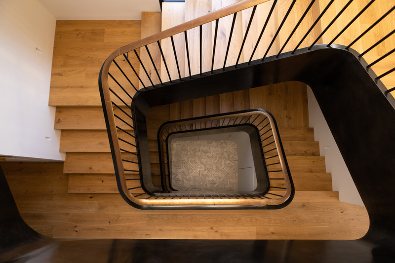 Press kit | 2757-35 - Press release | Medium Plenty Gives a Sprawling Update to a Once Modest 1920s Spanish Revival Home - Medium Plenty - Residential Interior Design -   A bird's eye view of the stairwell and its mix of elegant materials as it cascades through each level of the residence.  - Photo credit:   Laure Joliet Photography  